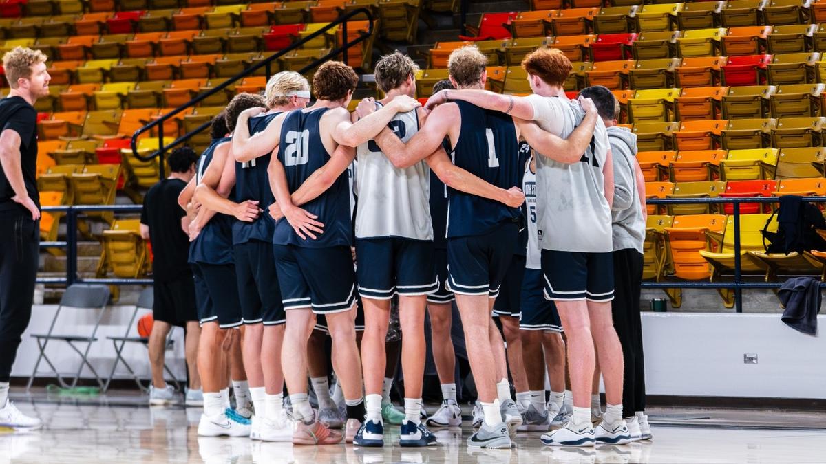 Utah State men's basketball players gather in a huddle at the Dee Glen Smith Spectrum.