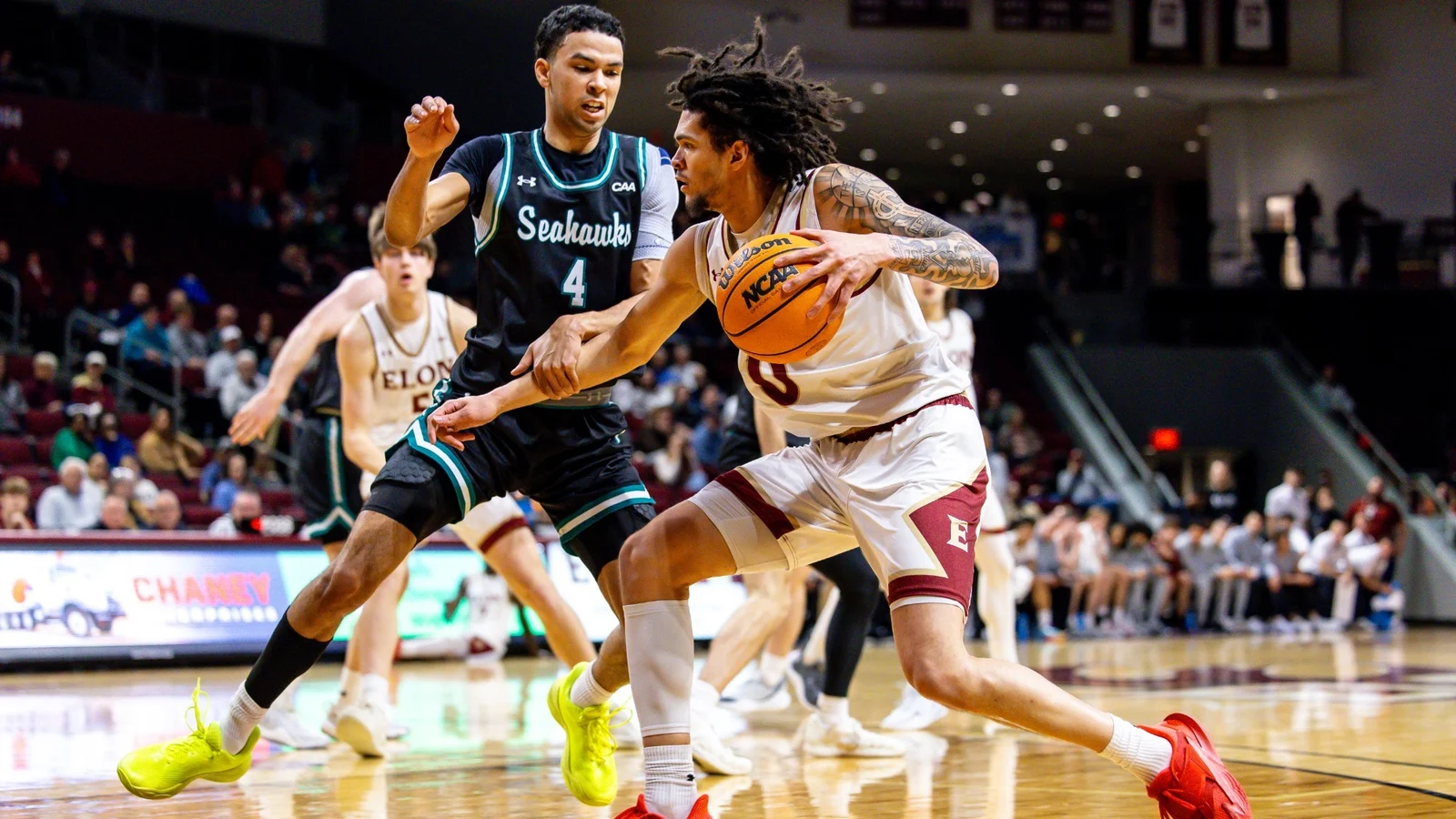 Elon guard Bryson Cokley drives against UNCW at Schar Center