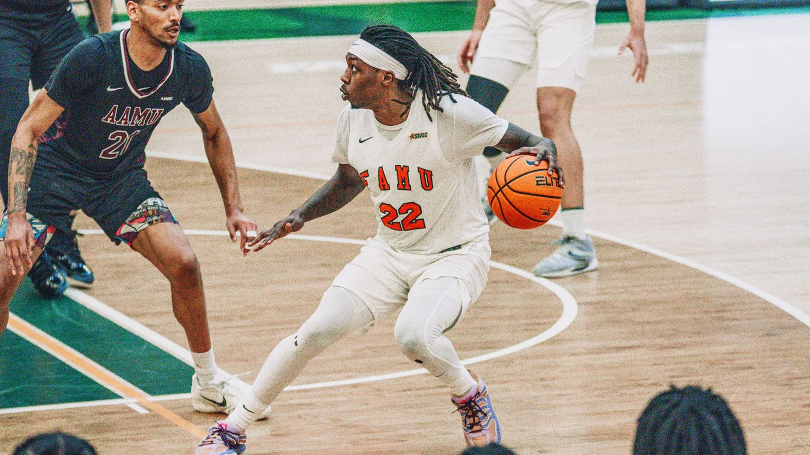 Florida A&M men's basketball player drives with the ball in a Rattlers uniform