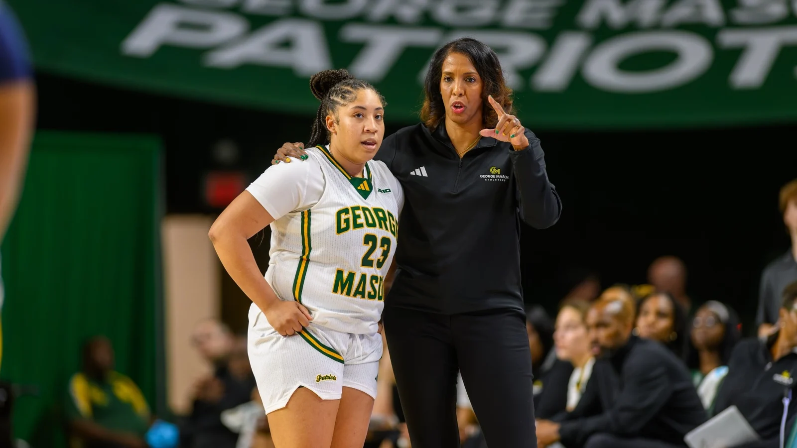 George Mason women's basketball player and coach on the sideline during a game