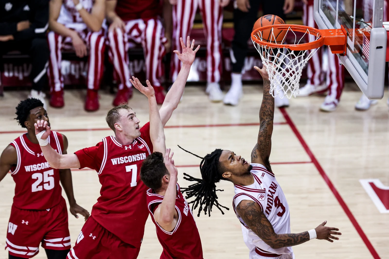 An Indiana men's basketball player attempts a layup against Wisconsin in a white Hoosiers uniform