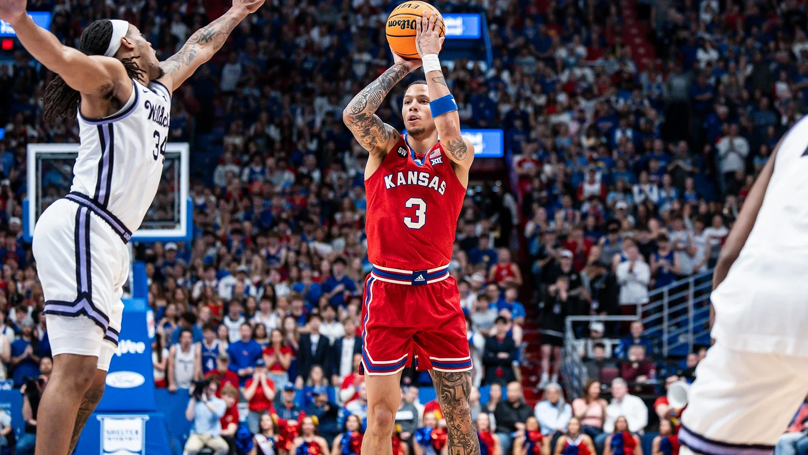 Kansas men's basketball player Tre White shoots against Kansas State in a red Jayhawks uniform