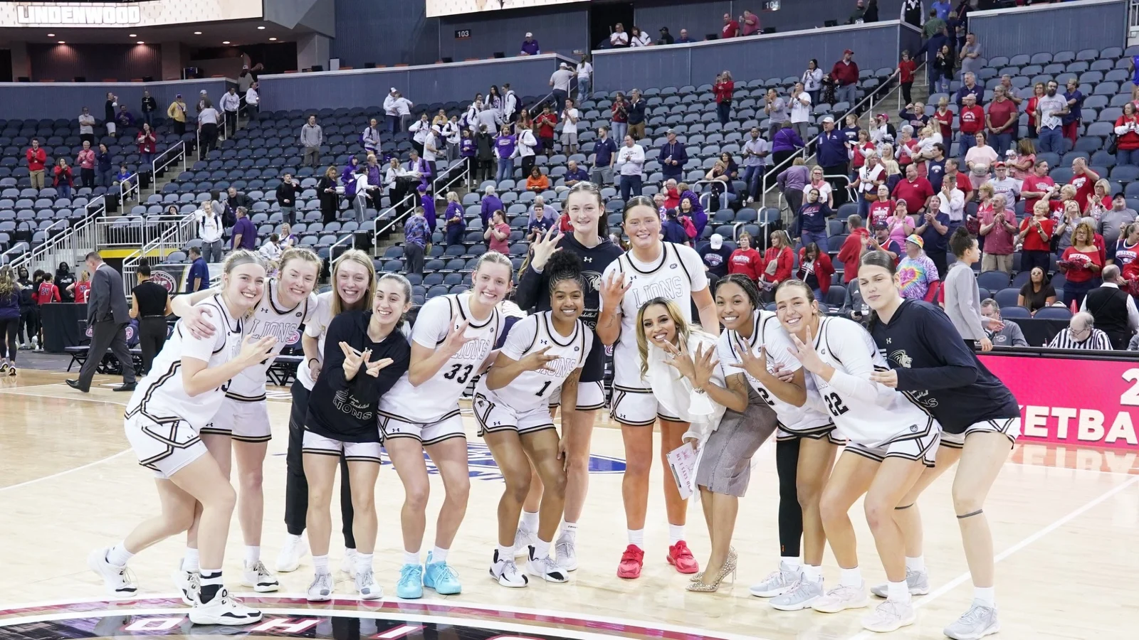 Lindenwood women's basketball players celebrate an OVC Tournament win in Lions uniforms