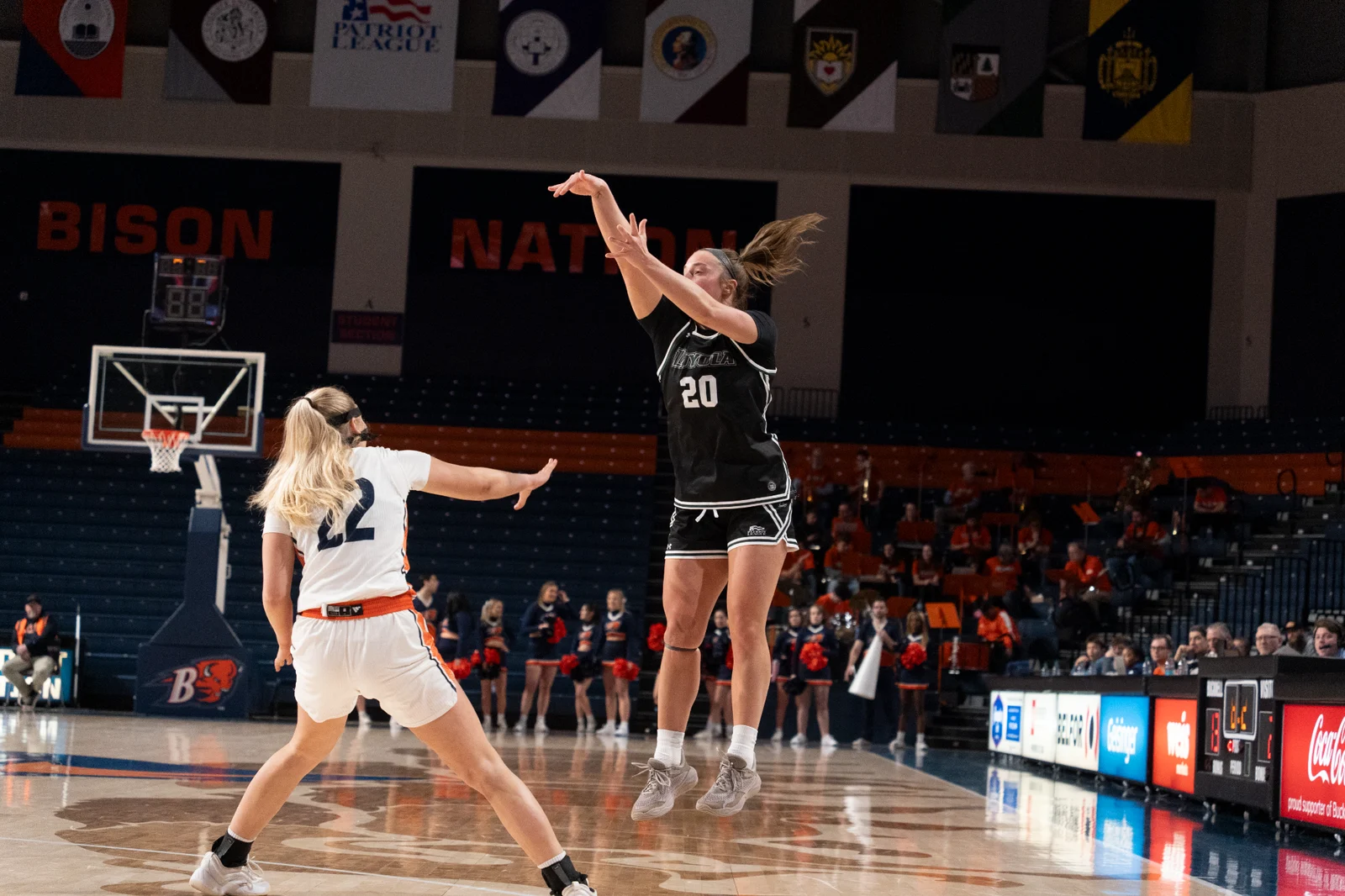 A Loyola Maryland women's basketball player shoots against Bucknell in a black Greyhounds uniform