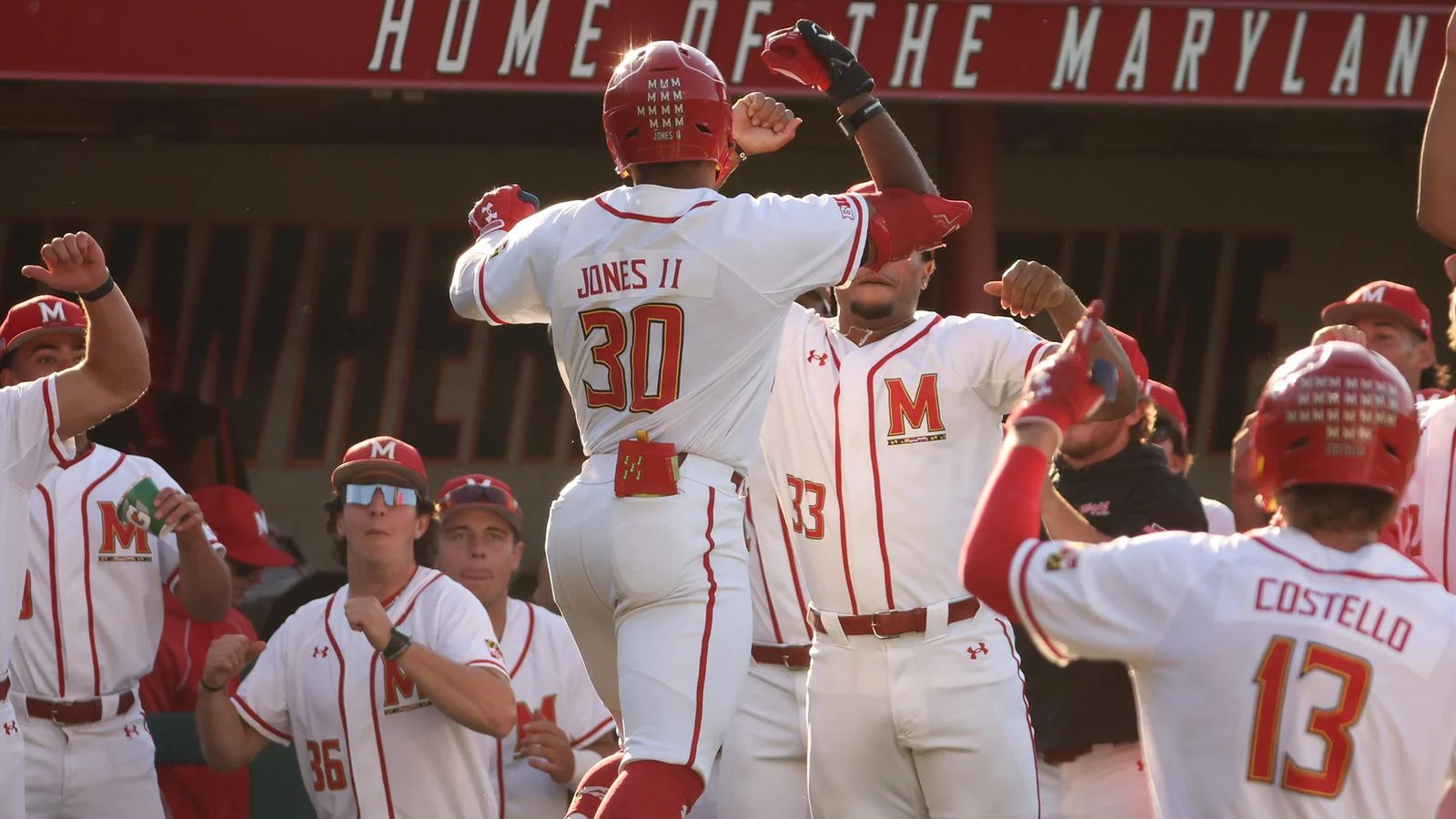 Maryland baseball teammates celebrate a home run in front of their dugout