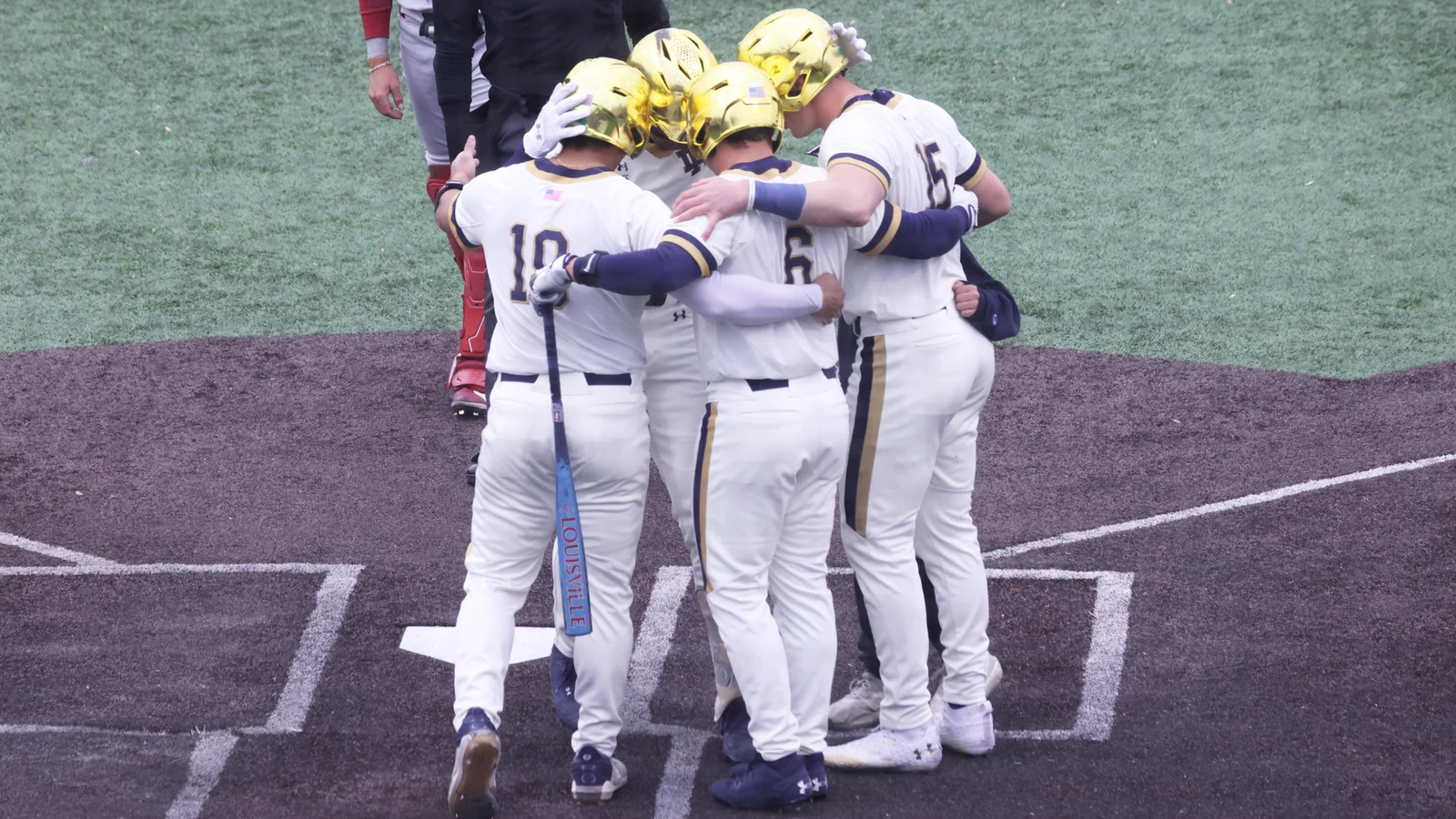 Notre Dame baseball players celebrate together at home plate