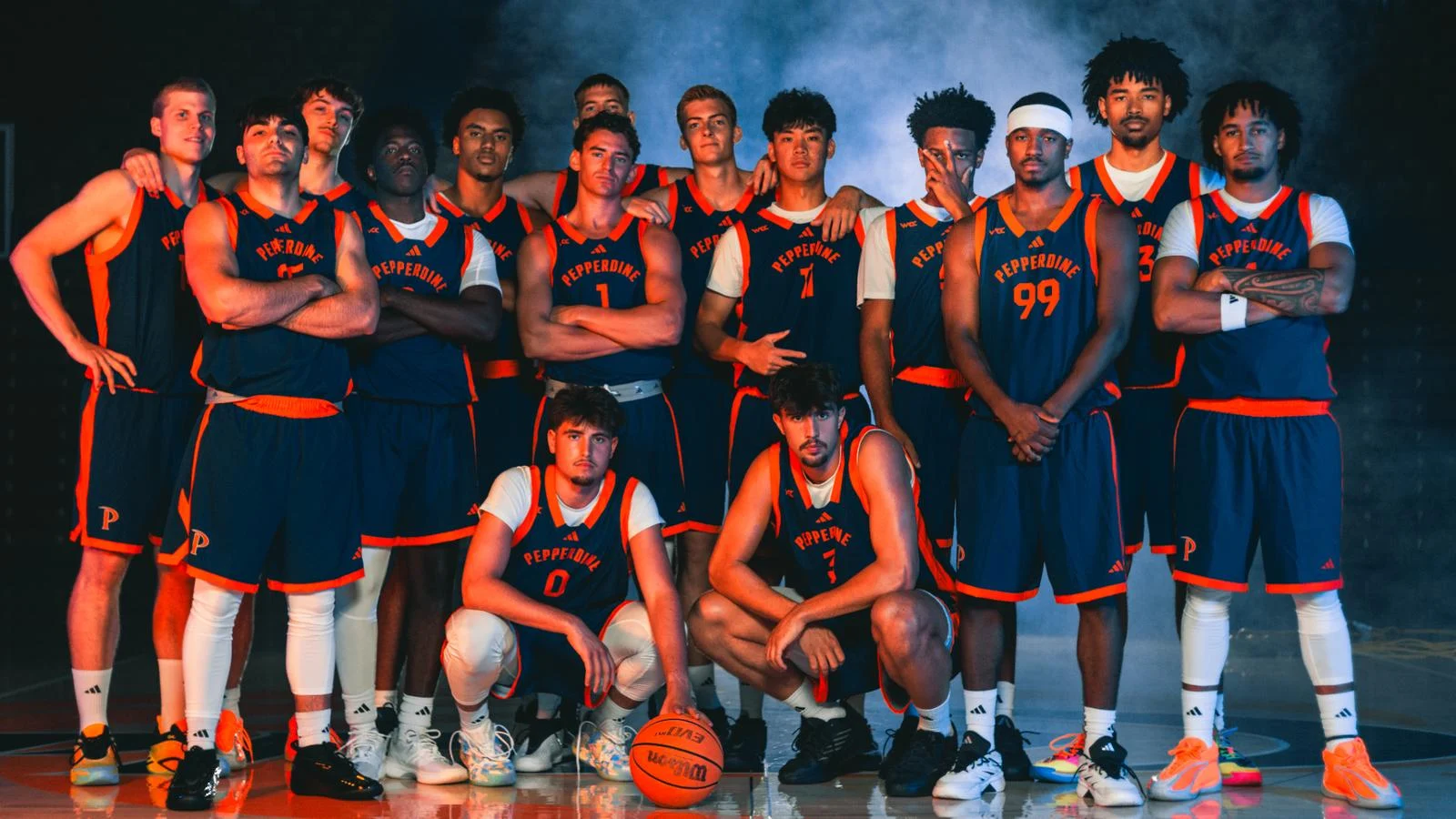 Pepperdine men's basketball team poses together in Waves uniforms