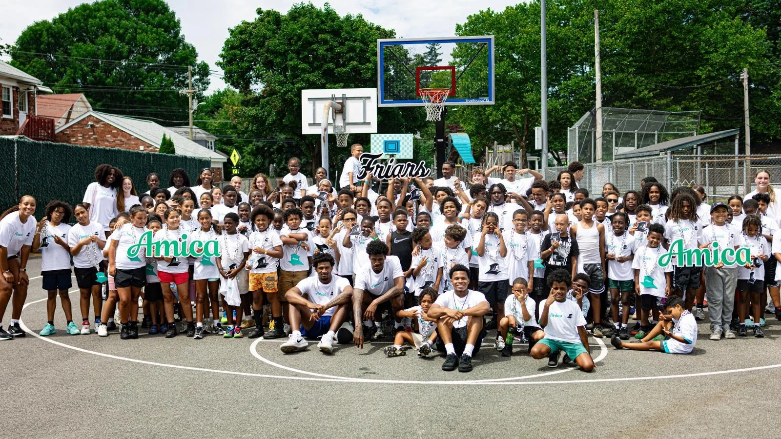 A group picture with the men's and women's basketball teams and the Providence Recreation Department Summer Program during a summer clinic