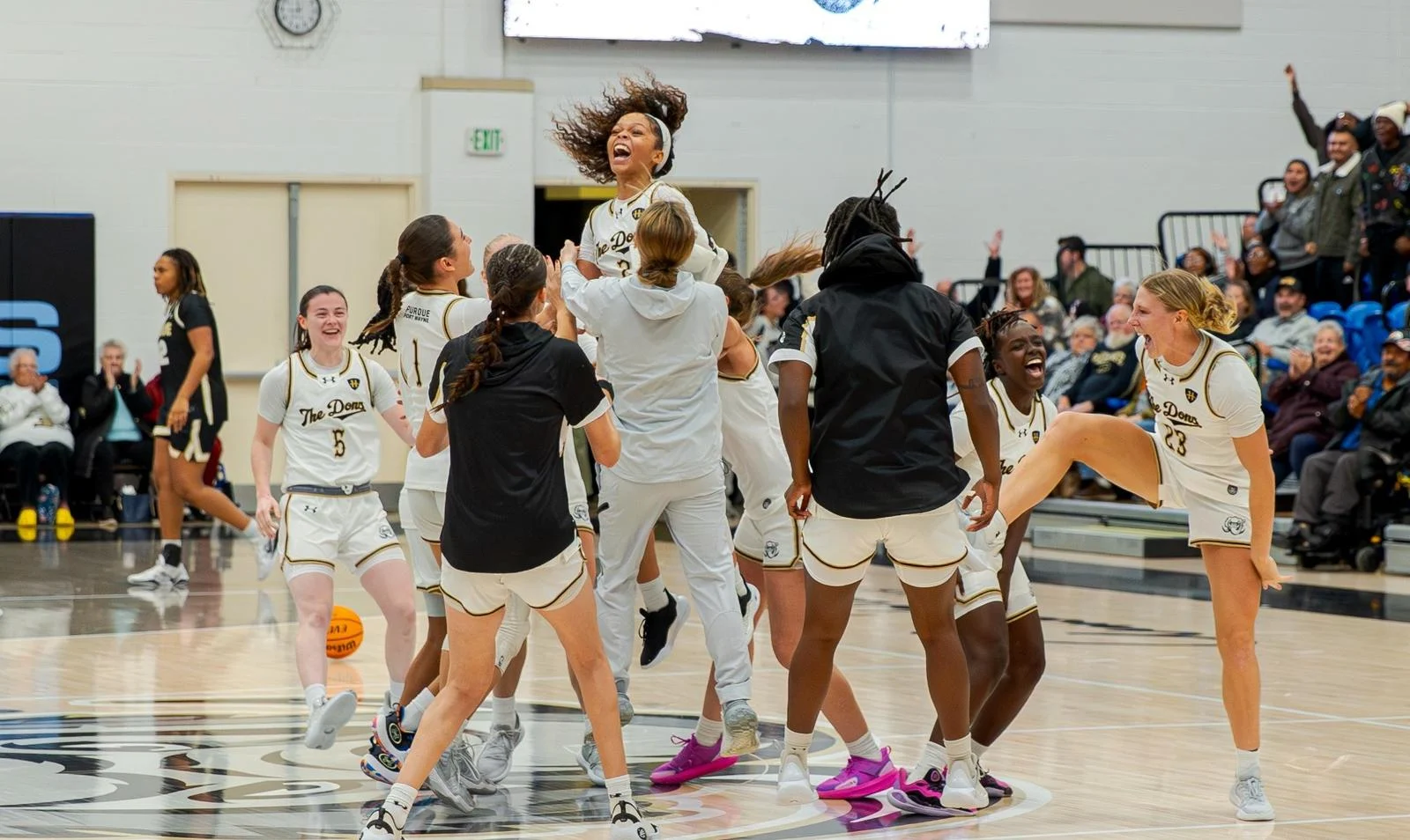 Purdue Fort Wayne women's basketball players celebrate their win over Purdue in Mastodons uniforms