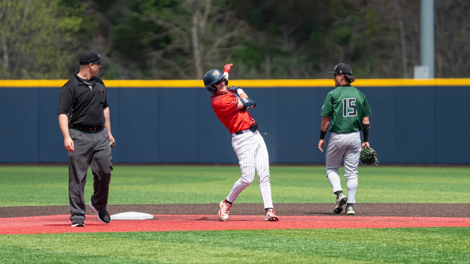 A Radford baseball player celebrates in a red Highlanders uniform