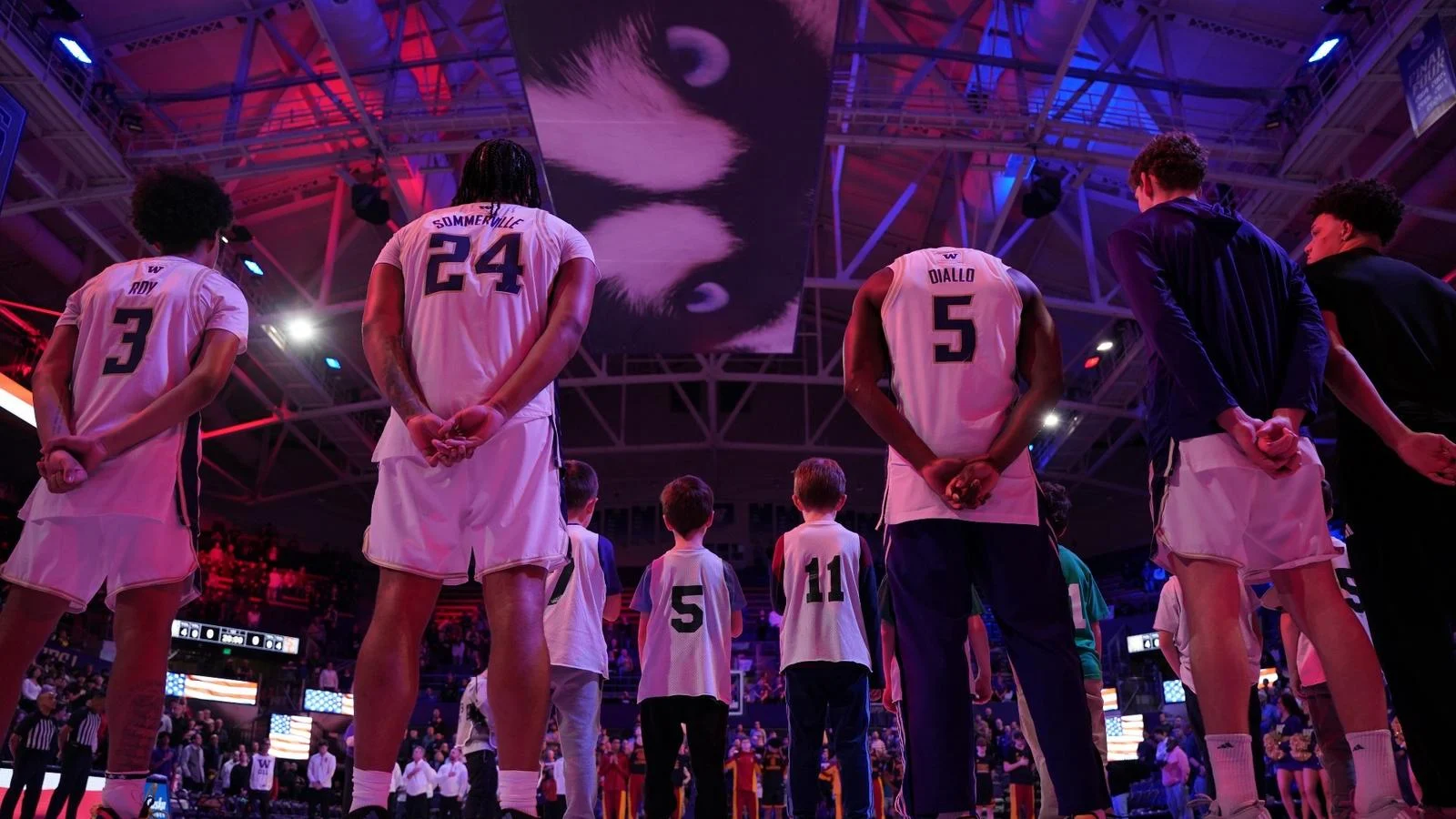 Washington men's basketball players line up together before a home game in Huskies uniforms